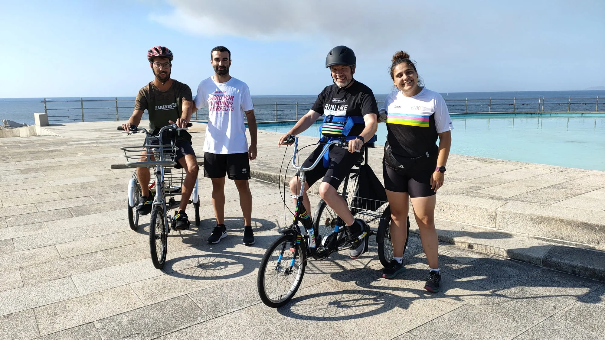 Grupo de persoas compartindo unha xornada inclusiva ao aire libre xunto ao mar.