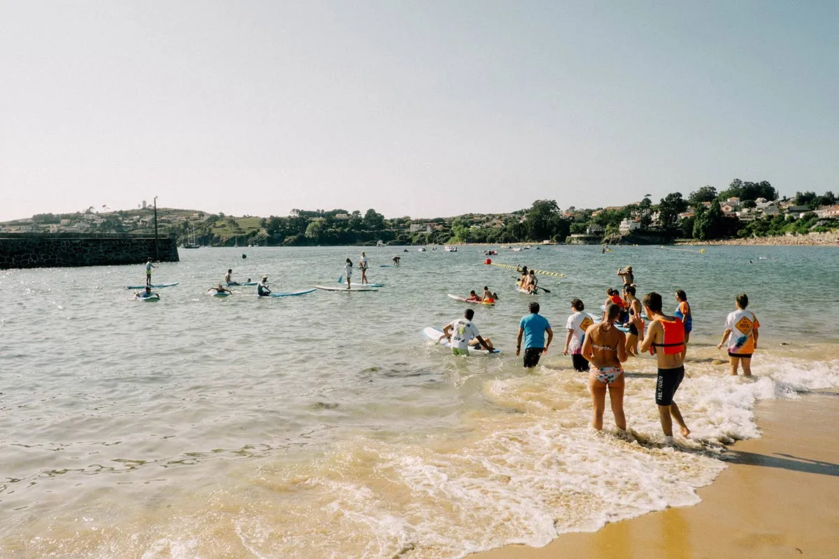Grupo de persoas participando en actividades de voluntariado na praia.